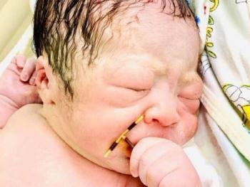 صور لمولود حديث الولادة بحمل وسيلة منع حمل أمه بين يديه